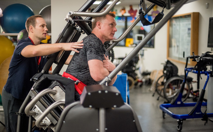 Exercise physiologist works with client on All Core 360 equipment.