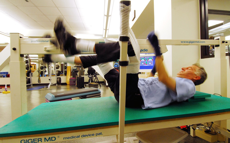 Male client laying on his back while using the Giger MD device.