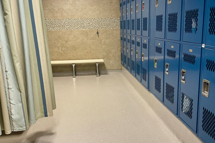 Wall of blue lockers with a curtained area for changing