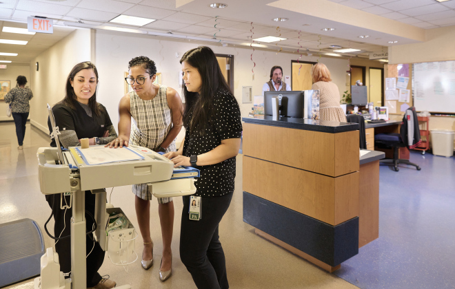 Neurologist Jacqueline Rosenthal, M.D., and Advanced Practice Providers Jennifer Khong, PA-C, and Karen Kaye, PA-C, gather around a monitor to discuss patient care.