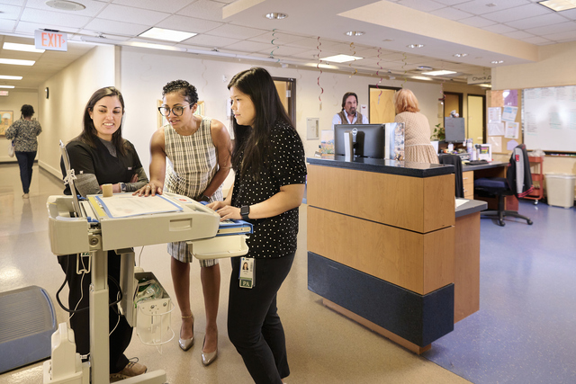 Neurologist Jacqueline Rosenthal, M.D., and Advanced Practice Providers Jennifer Khong, PA-C, and Karen Kaye, PA-C, gather around a monitor to discuss patient care.