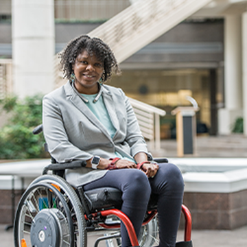 April Ross smiling outside of Shepherd Center while seated in her wheelchair