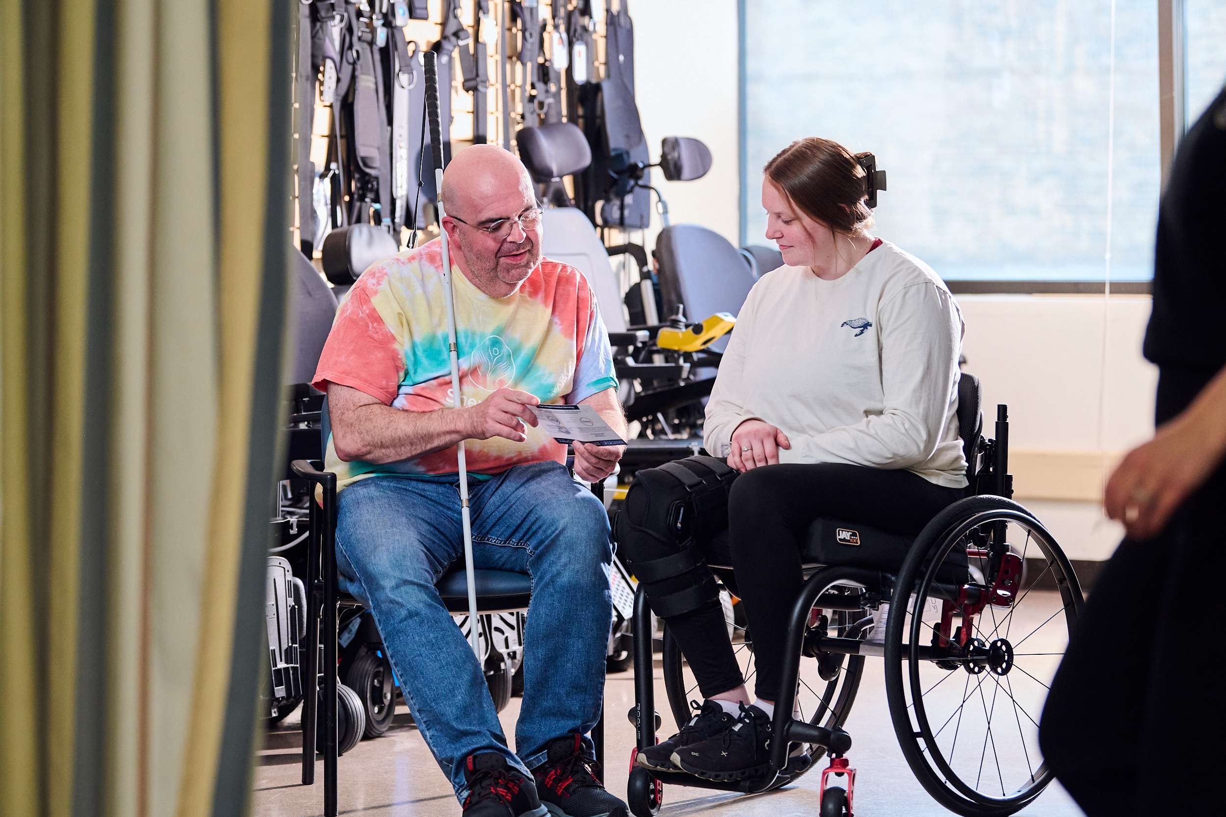 Case manager Danny Housley meets with female patient in the Wheelchair Seating & Mobility Clinic to assist in reviewing equipment funding resources.