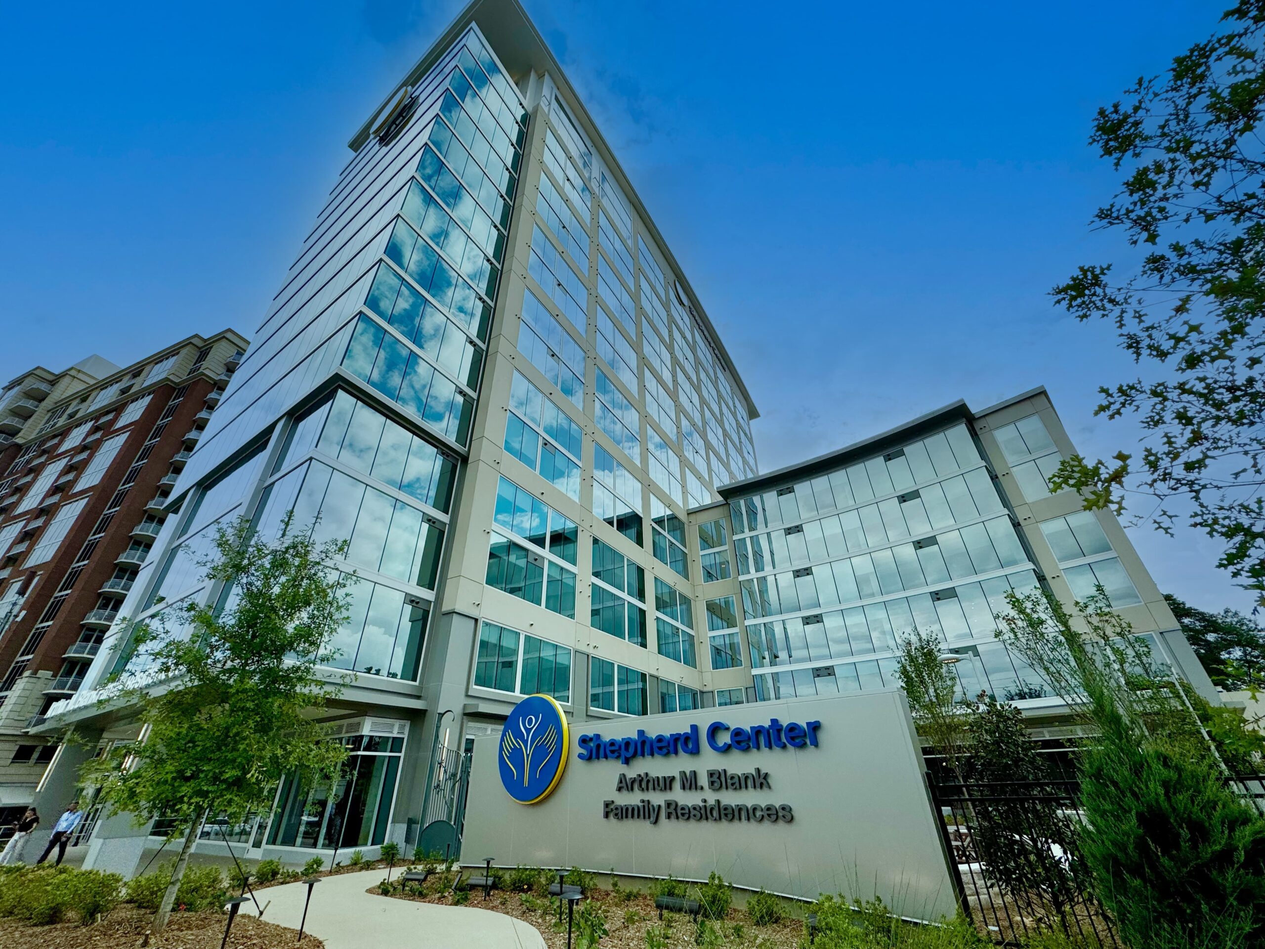 A modern multi-story glass building with the sign 