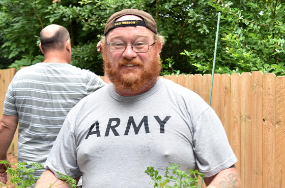 A bearded man wearing glasses and a cap with 