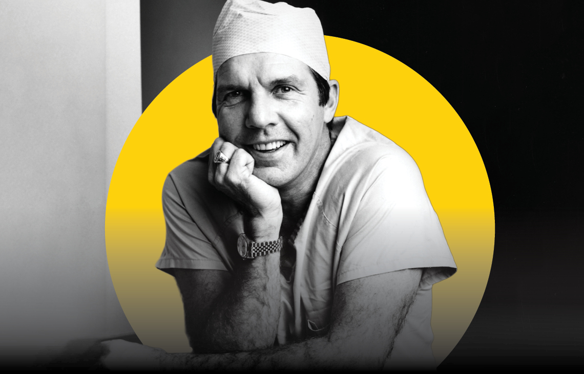 A smiling man in medical scrubs and a surgical cap rests his chin on his hand. The background is black and white with a yellow circle behind him.