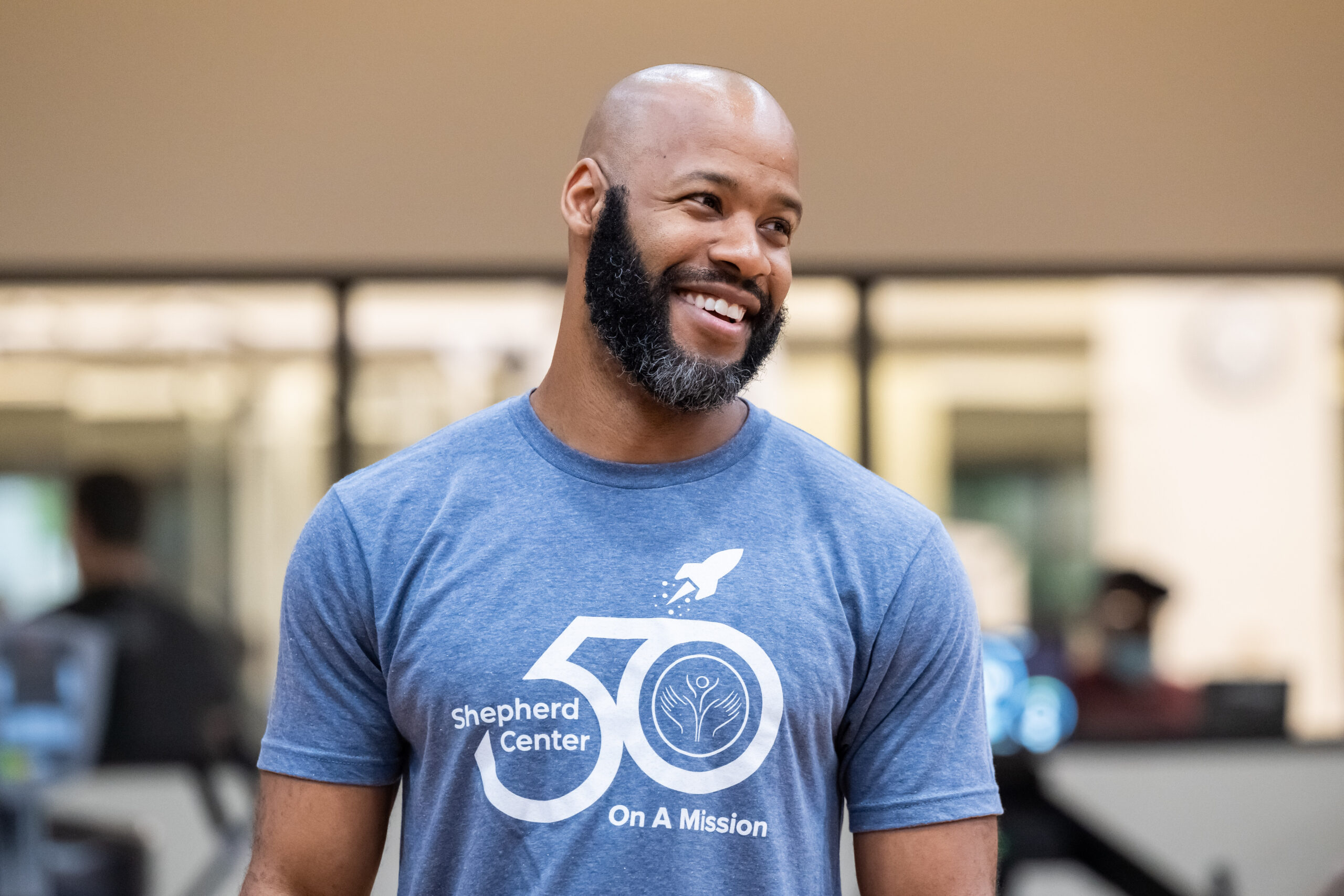 Smiling man with a beard wearing a blue 