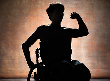 Silhouette of a person sitting in a wheelchair, flexing their arm in a gesture of strength, with a textured, warmly lit background.